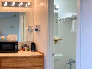 a bathroom with a sink, toilet, and mirror at Rodeway Inn & Suites in Omak