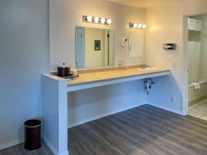 y baño con lavabo y espejo. en Rodeway Inn & Suites Omak - Okanogan, en Omak