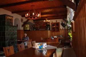 un hombre sentado en una mesa en un restaurante en Wellness Hotel Pension & Gaststätte Riedel, en Kurort Oberwiesenthal