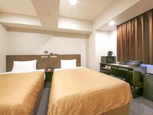 a hotel room with two beds and a television at HOTEL LiVEMAX Chiba Chuo-Ekimae in Chiba