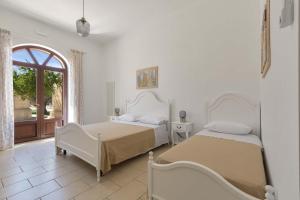 two beds in a white room with a window at Villa La Paiara by Perle di Puglia in Borgagne +62 photos
