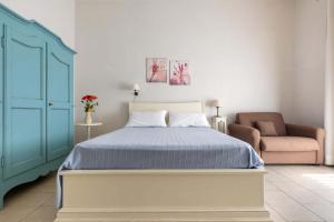 a bedroom with a blue bed and a chair at Villa La Paiara by BarbarHouse in Borgagne