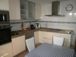 a kitchen with a table and chairs and a clock on the wall at Holiday Home Ribera del Tajo in Toledo