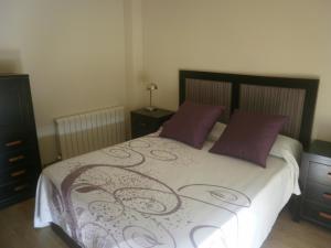 a bedroom with a large bed with purple pillows at Holiday Home Ribera del Tajo in Toledo