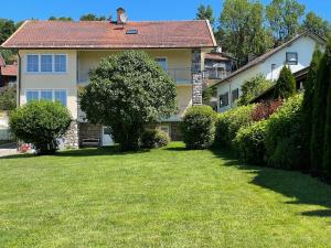 a large house with a yard in front of it at Haus Beate, FeWo im Bienenparadies in Kirchberg
