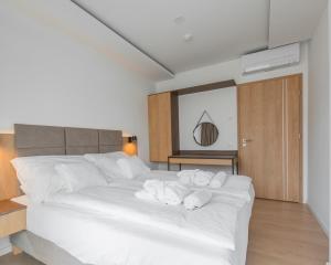 um quarto com uma cama branca e toalhas em H55 em Balatonlelle