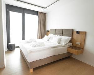 a bedroom with a large bed with white sheets at H55 in Balatonlelle