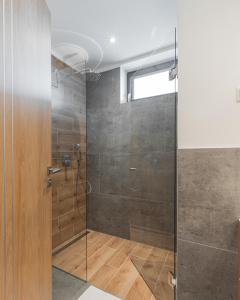 baño con ducha y puerta de cristal en H55, en Balatonlelle