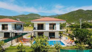 a villa with a swimming pool and mountains in the background at Kuytu Kaş Houses in Kas