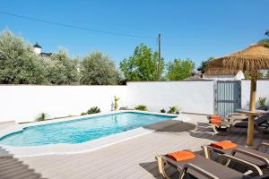 a swimming pool with chairs and a table at Casa Villanueva 1 -sólo Familias in Conil de la Frontera