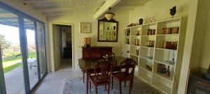 ein Esszimmer mit einem Tisch, Stühlen und einem Bücherregal in der Unterkunft Casas da Tapada Briteiros Casa dos Ficos in Guimarães