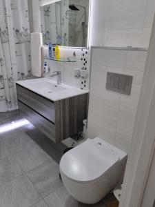 ein weißes Bad mit einem WC und einem Waschbecken in der Unterkunft Charming and modern apartment at heart of Tashkent in Taschkent