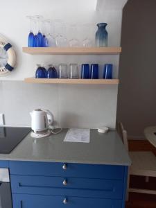 un bancone della cucina con vasi blu sugli scaffali di BELLEVUE RESORT Flat No 8 a Stilbaai