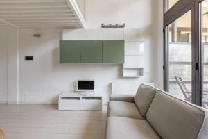 a living room with a couch and a tv at Elegant Loft with Balcony! in Milan