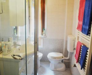 ein weißes Bad mit einem WC und einem Waschbecken in der Unterkunft Il Gioiellino di Modena - Elegant Apartment[☆☆☆☆☆] in Modena