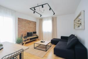 sala de estar con sofá negro y mesa en Apartman Tema en Podstrana