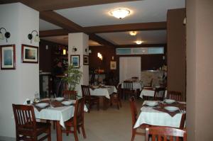 Un comedor con mesas y sillas con manteles blancos. en Apartmani Goran i Jelena Zec, en Budva 28 fotos más