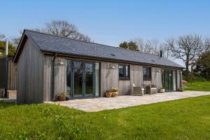 a wooden cabin with a patio in the grass at The Cabin in Haverfordwest