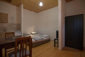 Zimmer mit einem Bett und einem Tisch sowie einer Küche in der Unterkunft Apartmani LUKA Perućac in Perućac