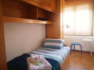 a small bedroom with a bed with a sink and a window at BELVEDERE, vistas al mar y terraza Luanco in Luanco +3 photos