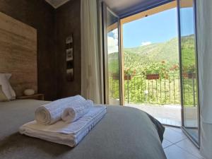 a bedroom with a bed with towels and a large window at Bed & Bike Frasassi in Falcioni