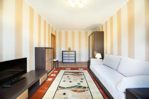 sala de estar con sofá blanco y TV en Busines Brusnika Apartment Tyoply Stan, en Moscú