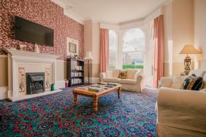 a living room with a fireplace and a tv at The Maynard in Scarborough