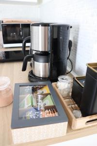 a kitchen counter with a coffee maker and a book at La Petite Boire - Chambres d'hôtes près d'Angers in Mûrs-Érigné