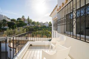 einen Balkon mit weißen Stühlen und Aussicht in der Unterkunft Casa de mi Padre Full Access in Casas de Torrat