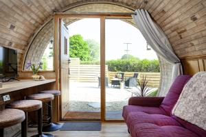 a living room with a couch and a sliding glass door at The Charm Inn, The Little Burrow, Nr Wells in Radstock