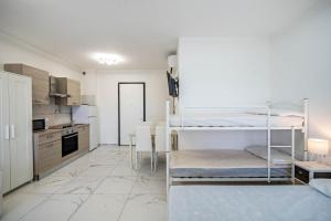 Pokój z 2 łóżkami piętrowymi i kuchnią w obiekcie Planet Suite 303 w Bibione