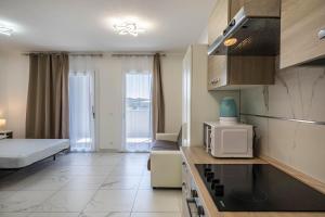 Pokój z kuchnią z łóżkiem i kuchenką mikrofalową w obiekcie Planet Suite 303 w Bibione