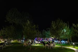 a group of people sitting in chairs in a park at night at The Allure Grand - Riverside Resort & Spa in Manāli +54 photos