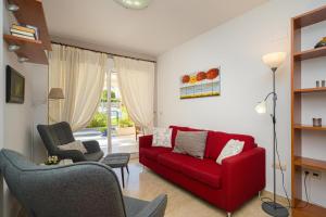 a living room with a red couch and two chairs at Estrella 2 BA Spaniahome in Albir