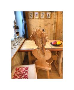 a dining room with a wooden table with a chair at NONNA PINA Appartamento FIORI in Padola