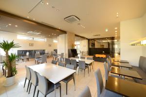 a dining room with tables and chairs in a building at Montein Hotel in Kitakami