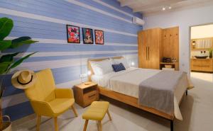um quarto com uma cama, uma cadeira amarela e uma cadeira em Ideal Boutique Hotel em Parga