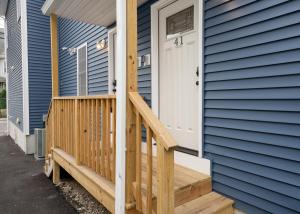 a porch with a white door on a blue house at 41-Convenient Townhouse in Quincy