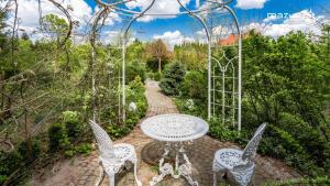 patio ze stołem i krzesłami w ogrodzie w obiekcie Apartament Parkowy 2 pokojowy w mieście Mrągowo