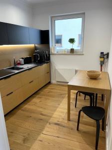 a kitchen with a table and a sink and a window at Sucha Street Apartments, Nowa Letnica,Gdańsk in Gdańsk