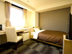 京都市にあるホテルリブマックスBUDGET京都五条のベッド、デスク、窓が備わるホテルルームです。