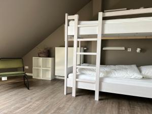 a bedroom with two bunk beds and a chair at HÖNOW HOTEL in Hoppegarten