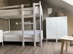 ein weißes Etagenbett in einem Zimmer mit einem Schrank in der Unterkunft HÖNOW HOTEL in Hoppegarten
