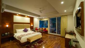 Habitación de hotel con cama y ventana grande en The Allure Grand Resort - A Riverside Resort and Spa, en Manali