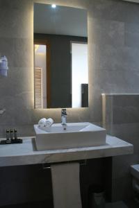 uma casa de banho com um lavatório branco e um espelho. em Valley Boutique Hotel em Safi