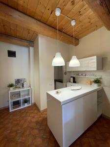 a kitchen with white counters and two pendant lights at Il Borghetto Medievale suite in Fabriano