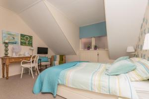 a bedroom with a bed and a desk at Hotel-Restaurant van der Weijde in Noordgouwe