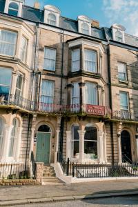 un gran edificio con una puerta verde en una calle en The Maynard, en Scarborough