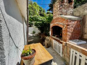 a patio with a brick oven with a wooden table at Apartments Rome in Baška