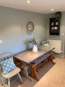 a dining room table with a vase of flowers on it at ‘The Nest’ A beautiful cottage in Devon in Axminster